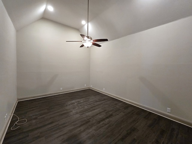 unfurnished room with vaulted ceiling, dark wood-type flooring, a ceiling fan, and baseboards