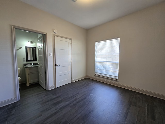 spare room with a sink, dark wood finished floors, and baseboards