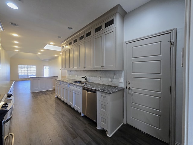 kitchen with decorative backsplash, glass insert cabinets, dark wood-type flooring, appliances with stainless steel finishes, and dark stone counters