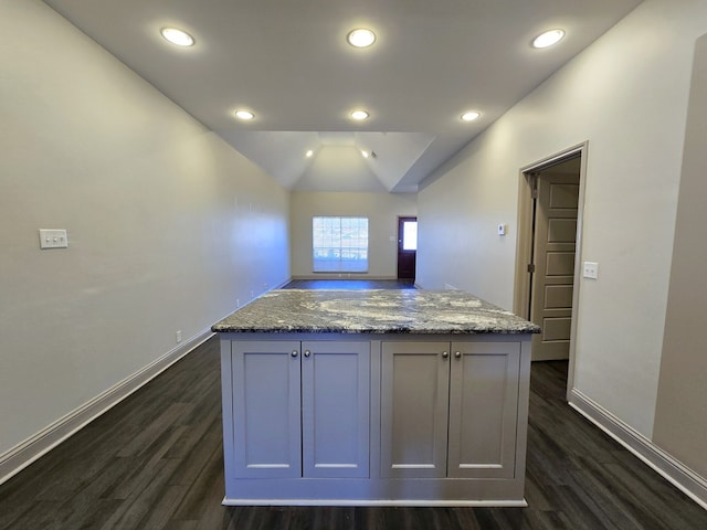 kitchen featuring a center island, dark wood-style flooring, baseboards, and light stone countertops