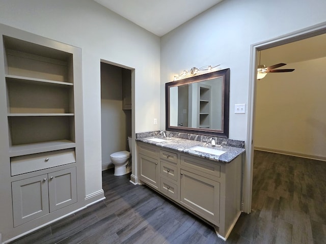 bathroom with double vanity, a sink, and wood finished floors