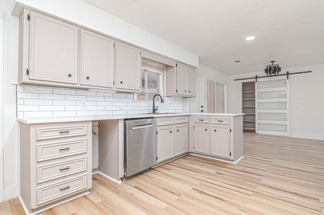 1017 Ward St, Midland, TX 79701 - kitchen featuring dishwasher, a sink, light countertops, a barn door, and recessed lighting