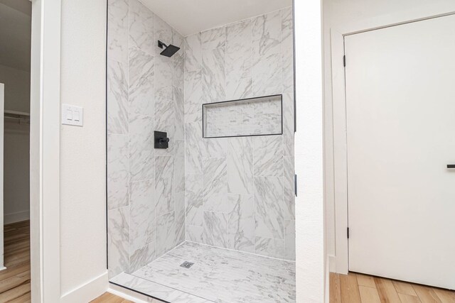 1017 Ward St, Midland, TX 79701 - full bath featuring tiled shower, wood finished floors, a spacious closet, and baseboards