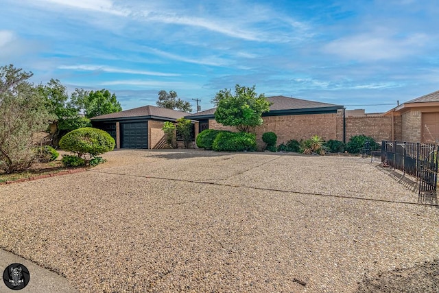 1017 Ward St, Midland, TX 79701 - ranch-style home featuring an attached garage, driveway, brick siding, and roof with shingles