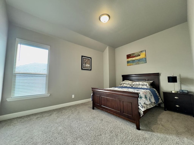 bedroom with baseboards, multiple windows, light carpet, and vaulted ceiling