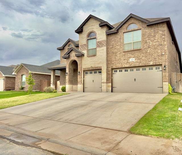 view of front of house with fence, an attached garage, a front lawn, brick siding, and concrete driveway