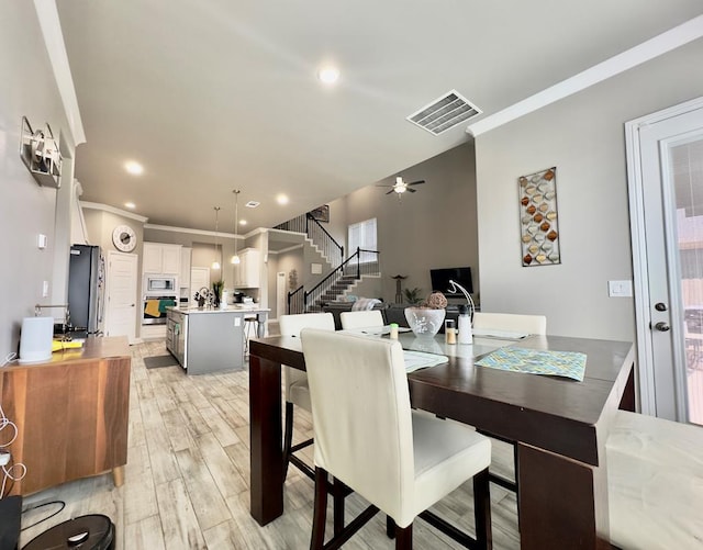 dining area featuring light wood finished floors, stairs, recessed lighting, visible vents, and ornamental molding