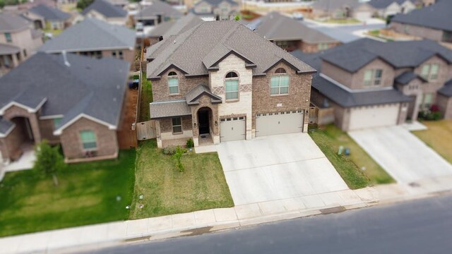 1815 Daybreak Way, Midland, TX 79705 - view of front facade with an attached garage, a residential view, roof with shingles, brick siding, and driveway