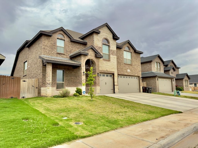 view of front facade with a garage, fence, a front yard, brick siding, and concrete driveway