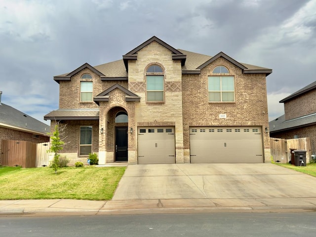 traditional home with brick siding, fence, a front yard, and a garage