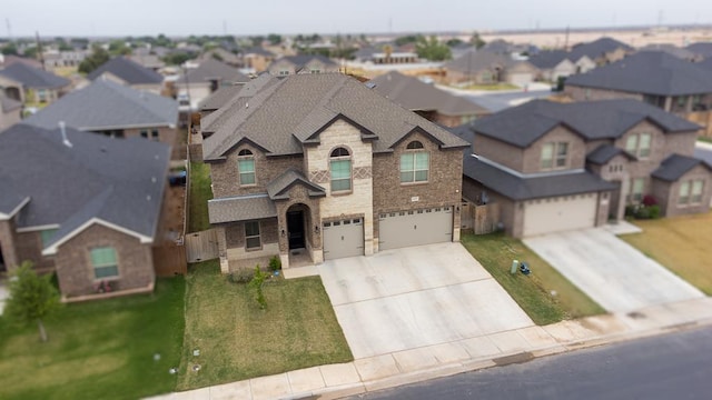 1815 Daybreak Way, Midland, TX 79705 - view of front of house with stone siding, an attached garage, a residential view, concrete driveway, and brick siding