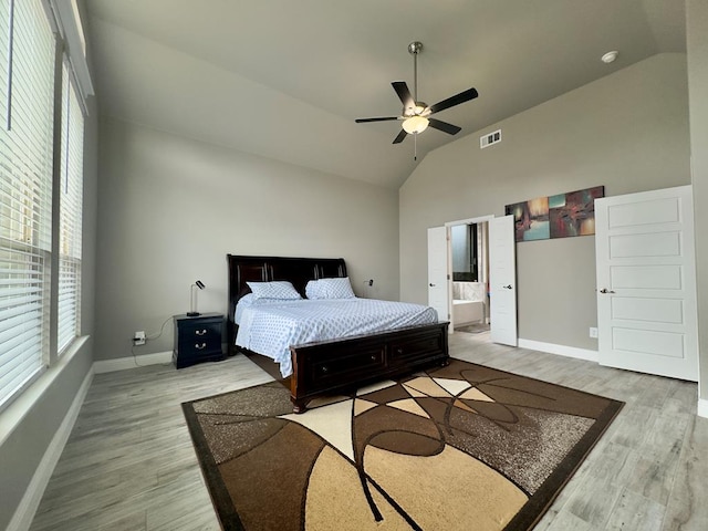 bedroom with baseboards, ensuite bath, wood finished floors, and visible vents