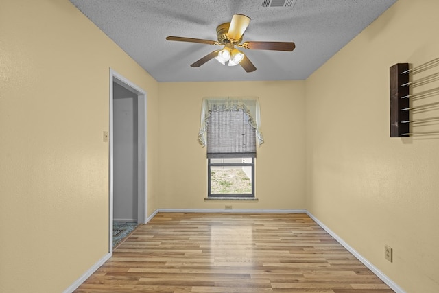 spare room with ceiling fan, a textured ceiling, and light hardwood / wood-style floors