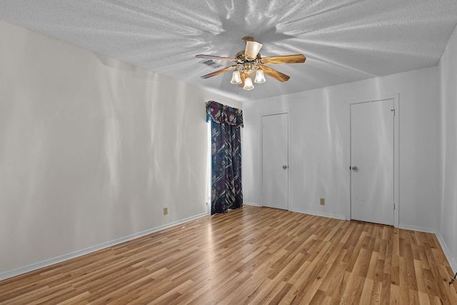 unfurnished room featuring ceiling fan, a textured ceiling, and light wood-type flooring