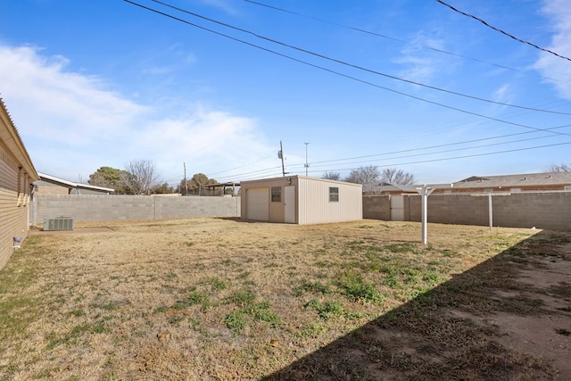 view of yard featuring an outbuilding, a garage, and central air condition unit