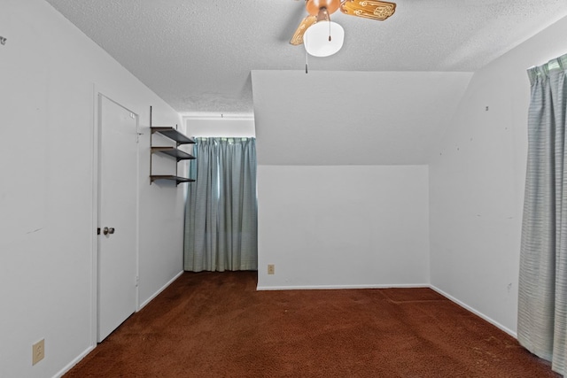 bonus room featuring lofted ceiling, a textured ceiling, and dark colored carpet