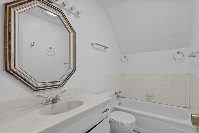 bathroom featuring a tub to relax in, toilet, vaulted ceiling, a textured ceiling, and vanity