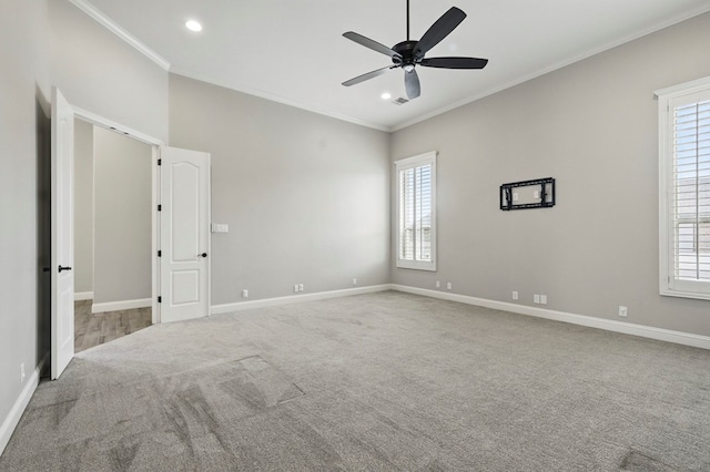 spare room featuring carpet, ceiling fan, healthy amount of natural light, crown molding, and baseboards