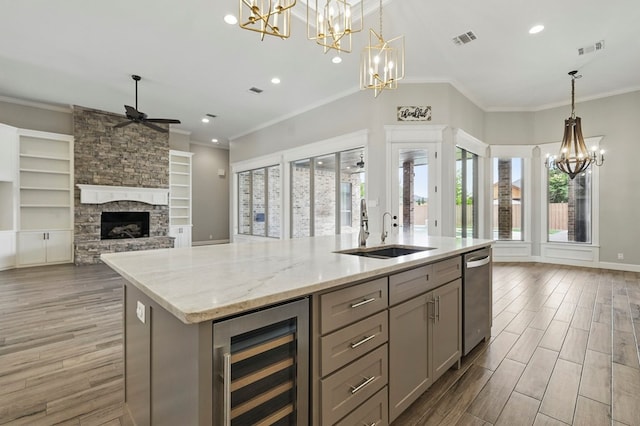 kitchen featuring beverage cooler, gray cabinetry, a chandelier, a sink, and open floor plan