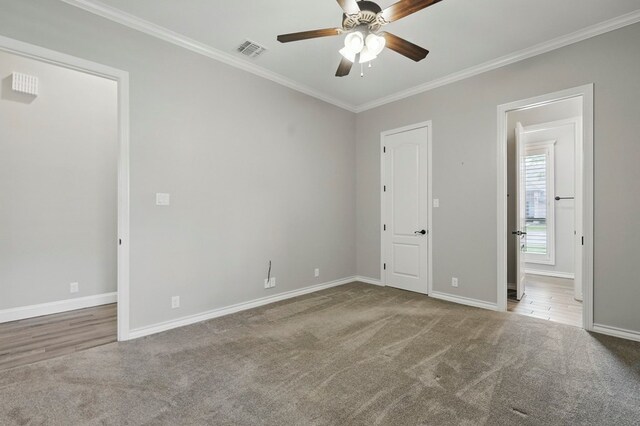 unfurnished bedroom with carpet flooring, crown molding, baseboards, ensuite bathroom, and ceiling fan