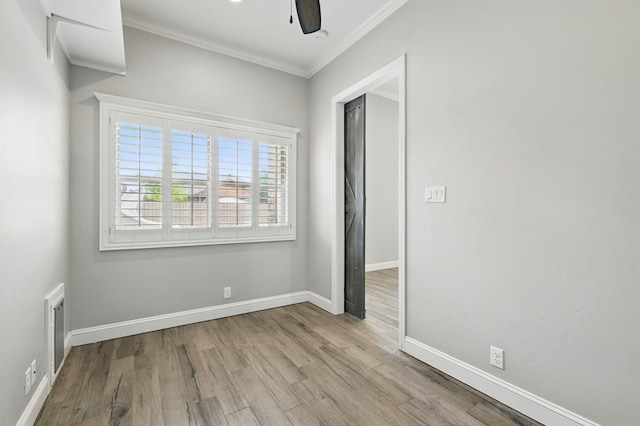 unfurnished room featuring wood finished floors, crown molding, baseboards, and a ceiling fan