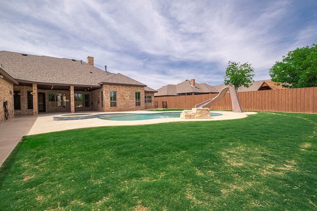 view of yard with a patio and a pool with connected hot tub
