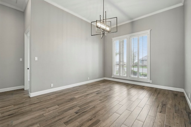 empty room with dark wood finished floors, baseboards, crown molding, and a chandelier