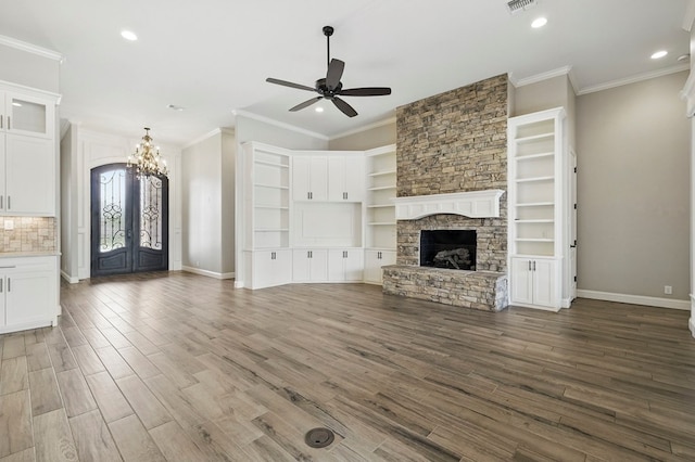 unfurnished living room featuring ceiling fan, a chandelier, recessed lighting, a fireplace, and wood finished floors