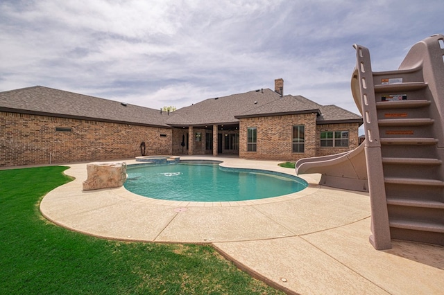view of pool featuring a water slide, a patio, and a pool with connected hot tub