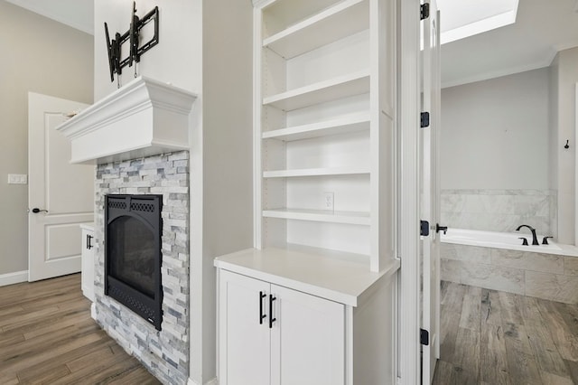 detailed view of a stone fireplace and wood finished floors