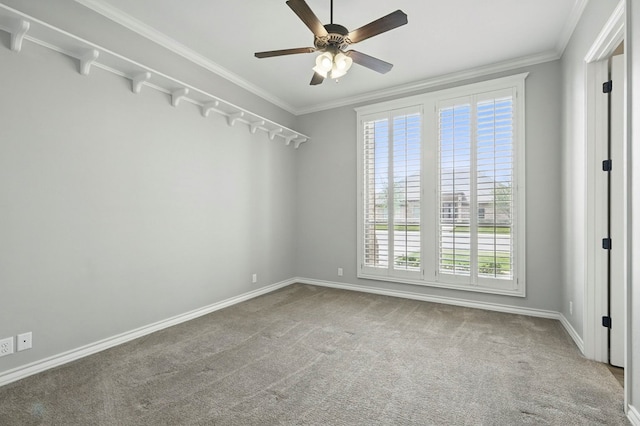 carpeted empty room with ceiling fan, baseboards, and ornamental molding