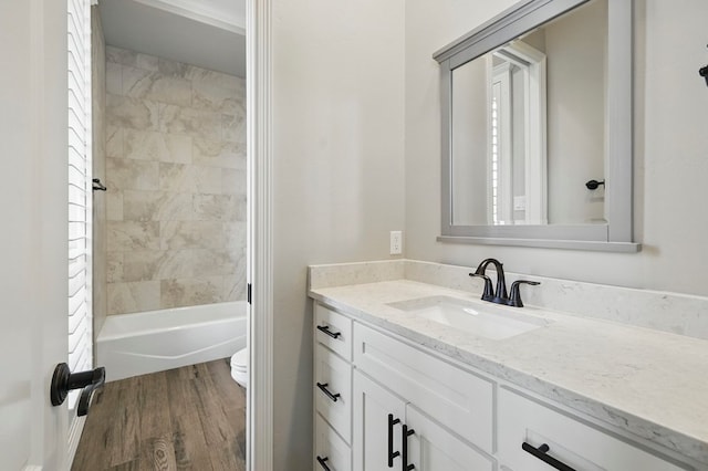 full bath featuring vanity, toilet, wood finished floors, and bathing tub / shower combination