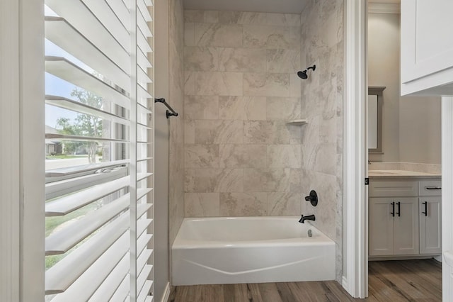 full bath with wood finished floors, washtub / shower combination, and vanity
