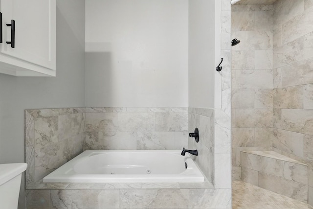 bathroom with a tile shower, a whirlpool tub, and toilet