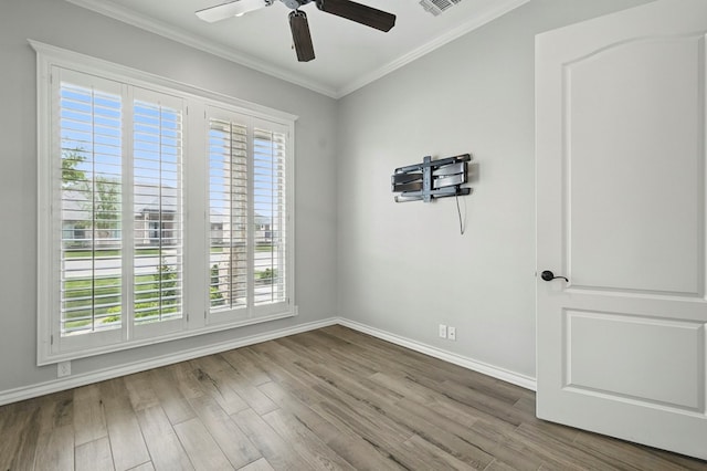 unfurnished room featuring a ceiling fan, ornamental molding, baseboards, and wood finished floors