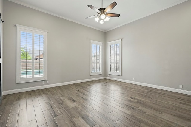 spare room featuring a ceiling fan, dark wood-type flooring, ornamental molding, and baseboards
