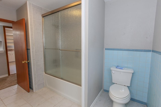 2004 State St, Big Spring, TX 79720 - full bath featuring combined bath / shower with glass door, tile walls, and wainscoting