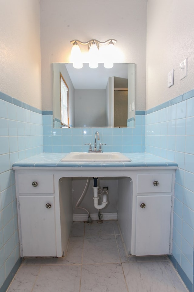 2004 State St, Big Spring, TX 79720 - bathroom featuring tile walls, a wainscoted wall, and vanity
