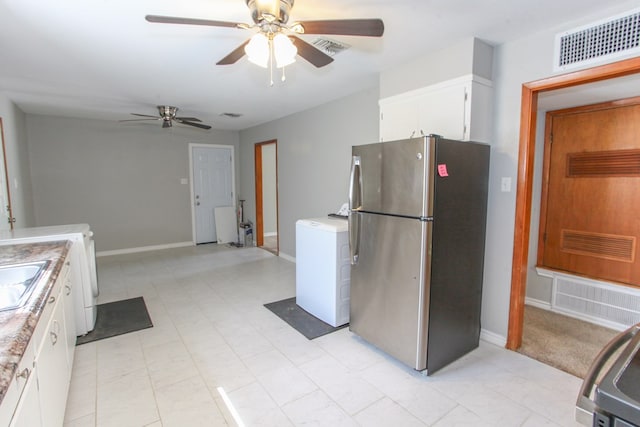 2004 State St, Big Spring, TX 79720 - kitchen featuring freestanding refrigerator, washer / dryer, a ceiling fan, light countertops, and white cabinetry
