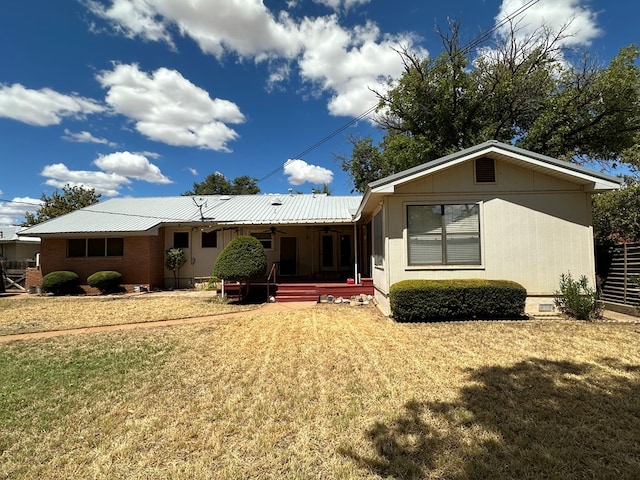 rear view of property with a yard and ceiling fan