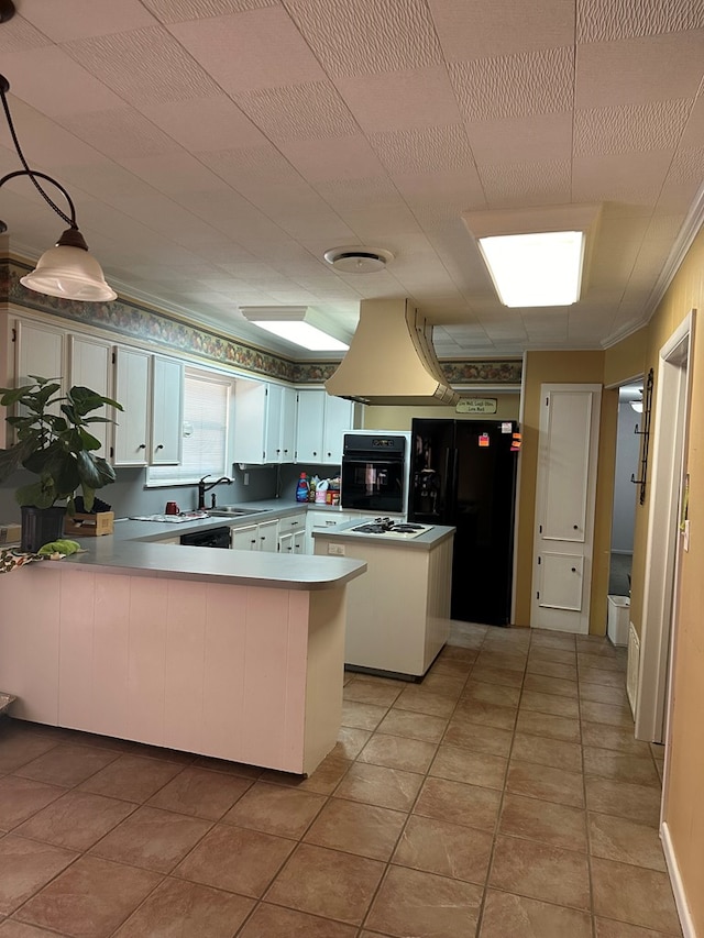 kitchen featuring kitchen peninsula, black appliances, pendant lighting, light tile patterned floors, and white cabinetry