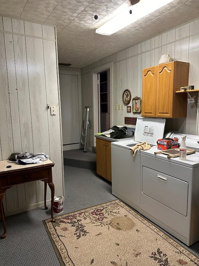 clothes washing area featuring cabinets, independent washer and dryer, and light carpet