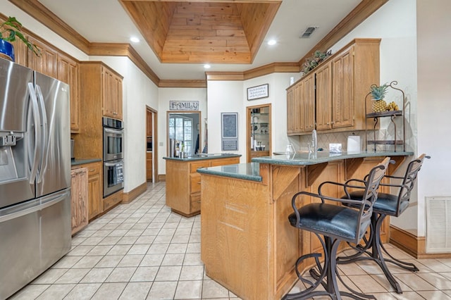 kitchen featuring visible vents, light tile patterned floors, a peninsula, a tray ceiling, and stainless steel appliances