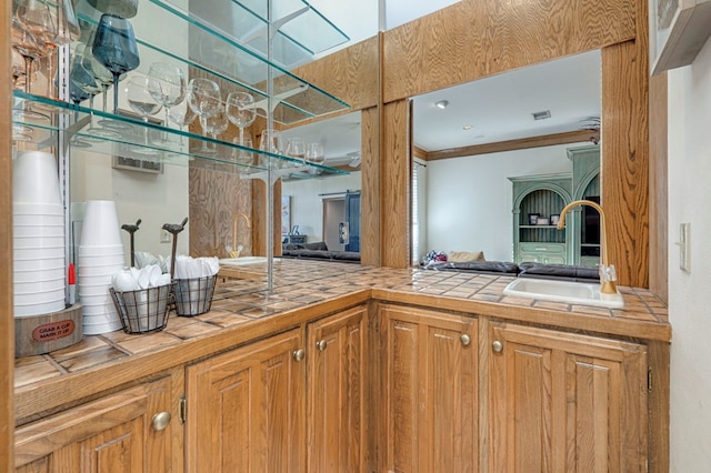 bathroom with visible vents, a sink, crown molding, and a skylight