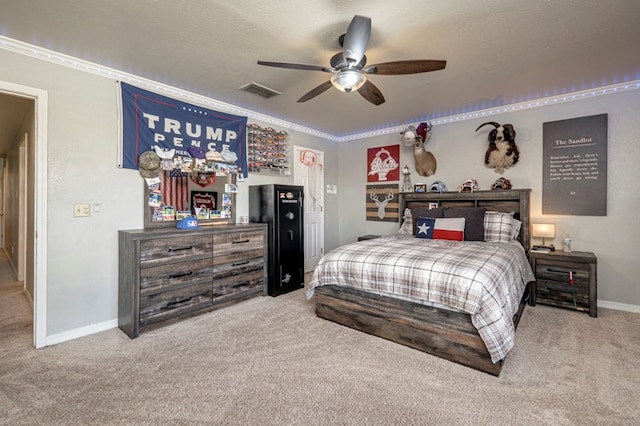 carpeted bedroom featuring ceiling fan, a textured ceiling, ornamental molding, visible vents, and baseboards
