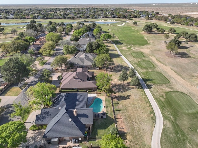 birds eye view of property with view of golf course and a water view