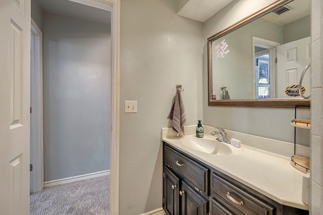 bathroom featuring vanity, baseboards, and visible vents