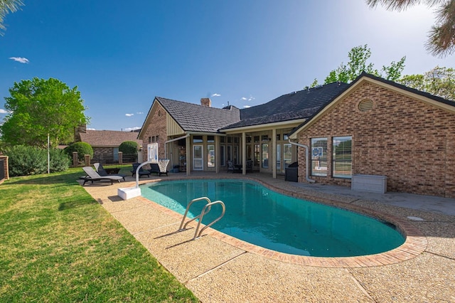 outdoor pool featuring a patio area and a yard