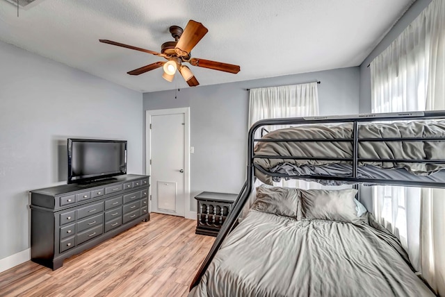 611 Storey Ave, Midland, TX 79703 - bedroom with light wood-type flooring, ceiling fan, baseboards, and a textured ceiling