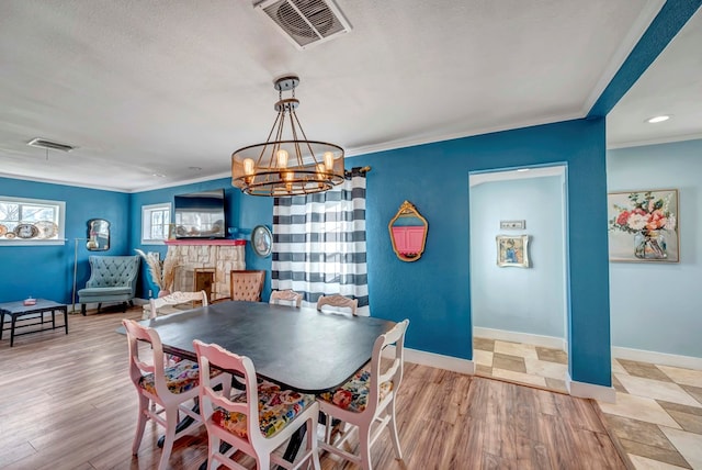 611 Storey Ave, Midland, TX 79703 - dining area with a chandelier, ornamental molding, light wood-type flooring, baseboards, and a textured ceiling